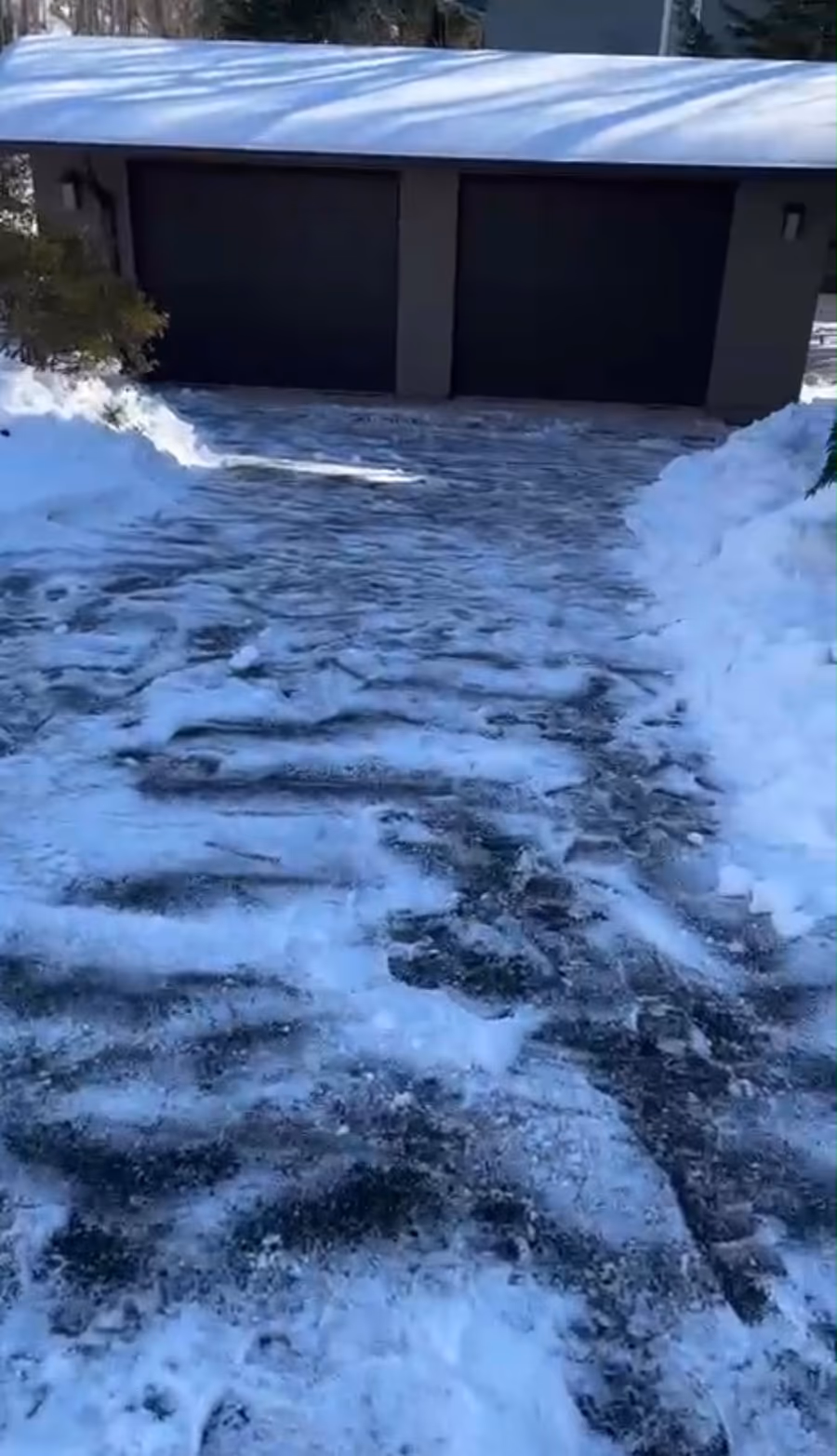 Residential driveway cleared of snow right up to the garage doors