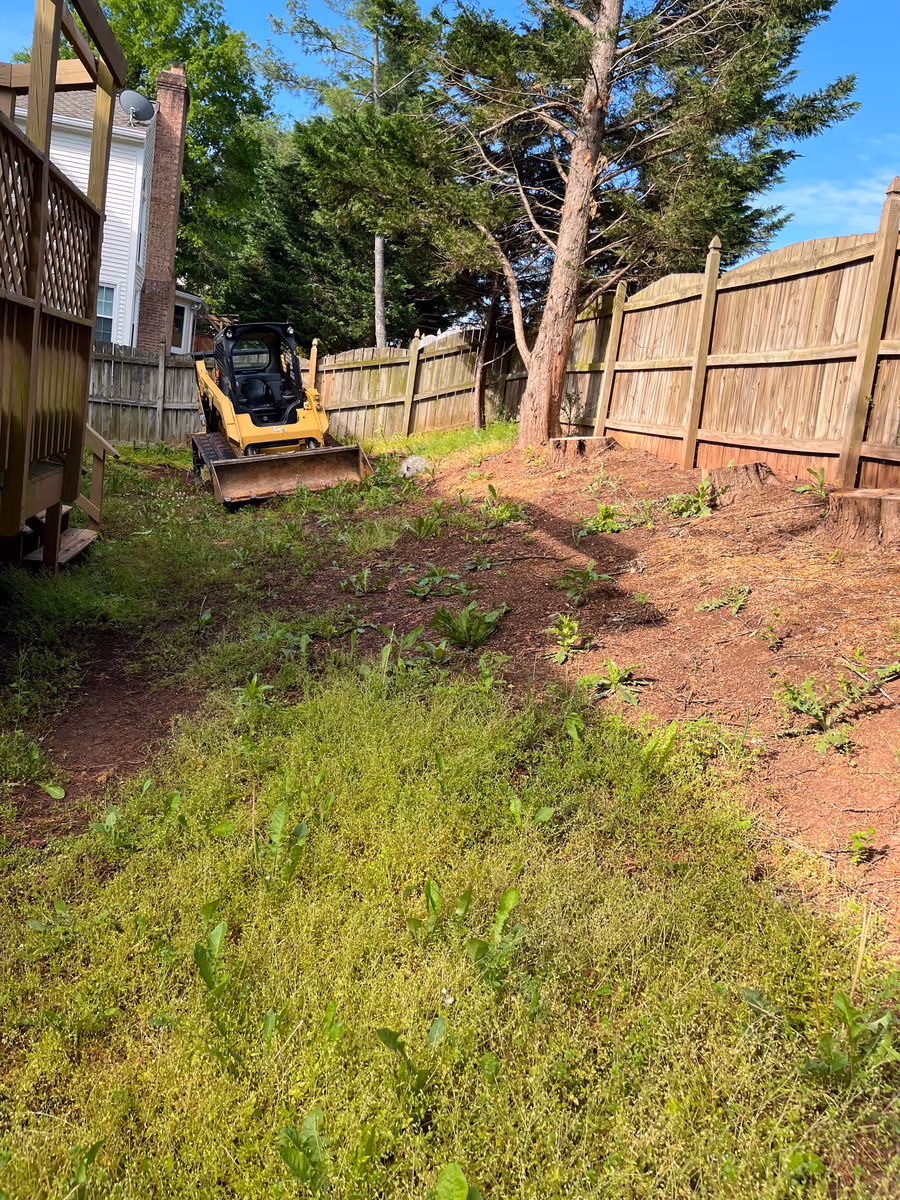 Skid steer loader grading a back yard during site preparation