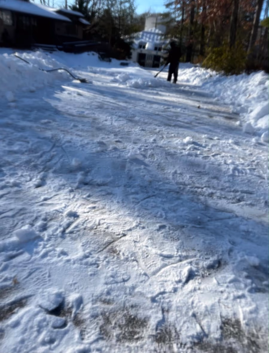 Long driveway being cleared after a snowfall, banks pushed back to the edges