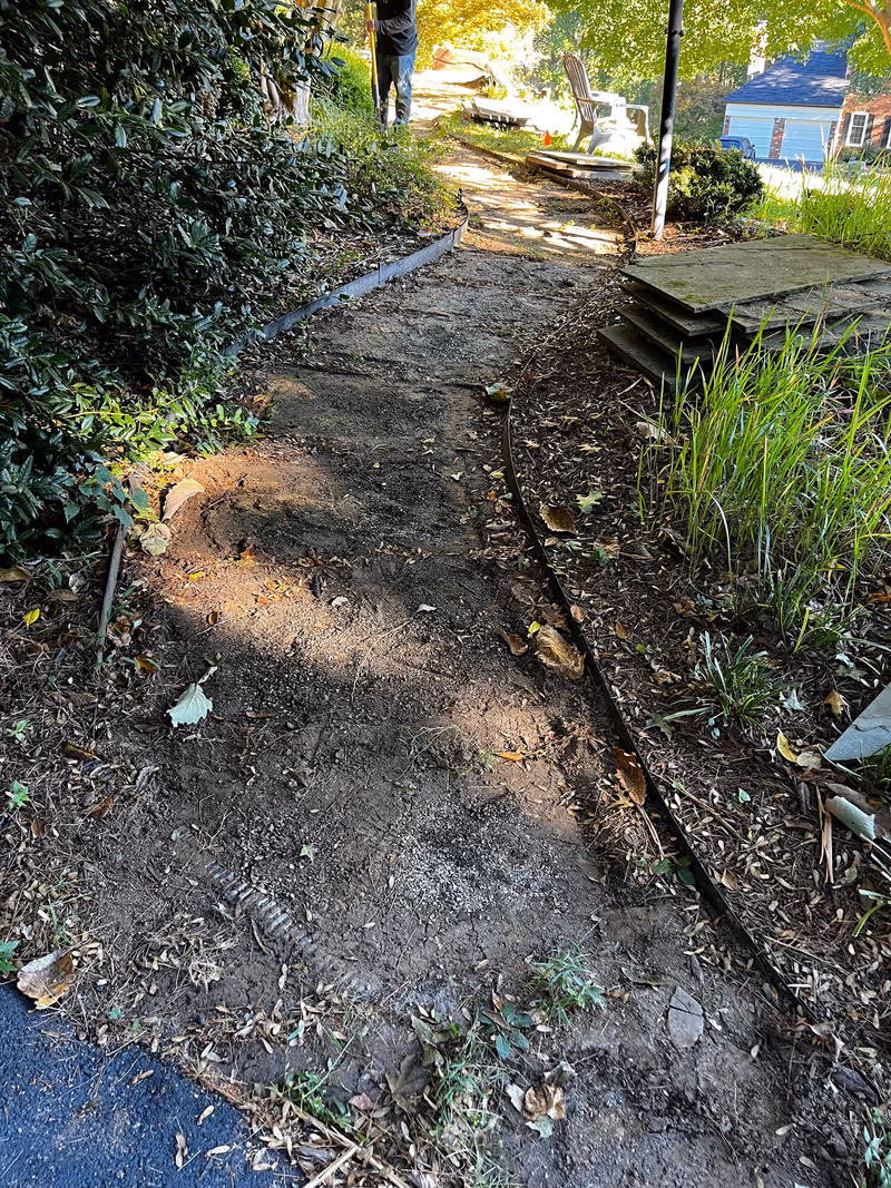 Excavated ground cleared and graded ahead of a new walkway installation